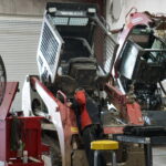 A man working on an old truck in a garage.