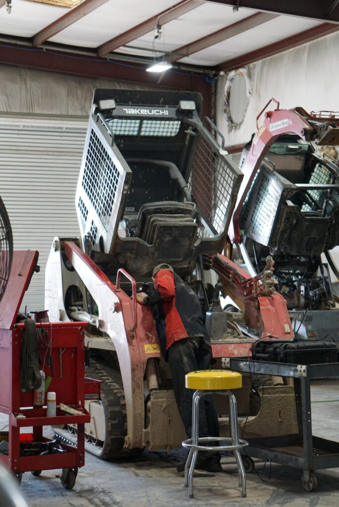 A man working on an old truck in a garage.