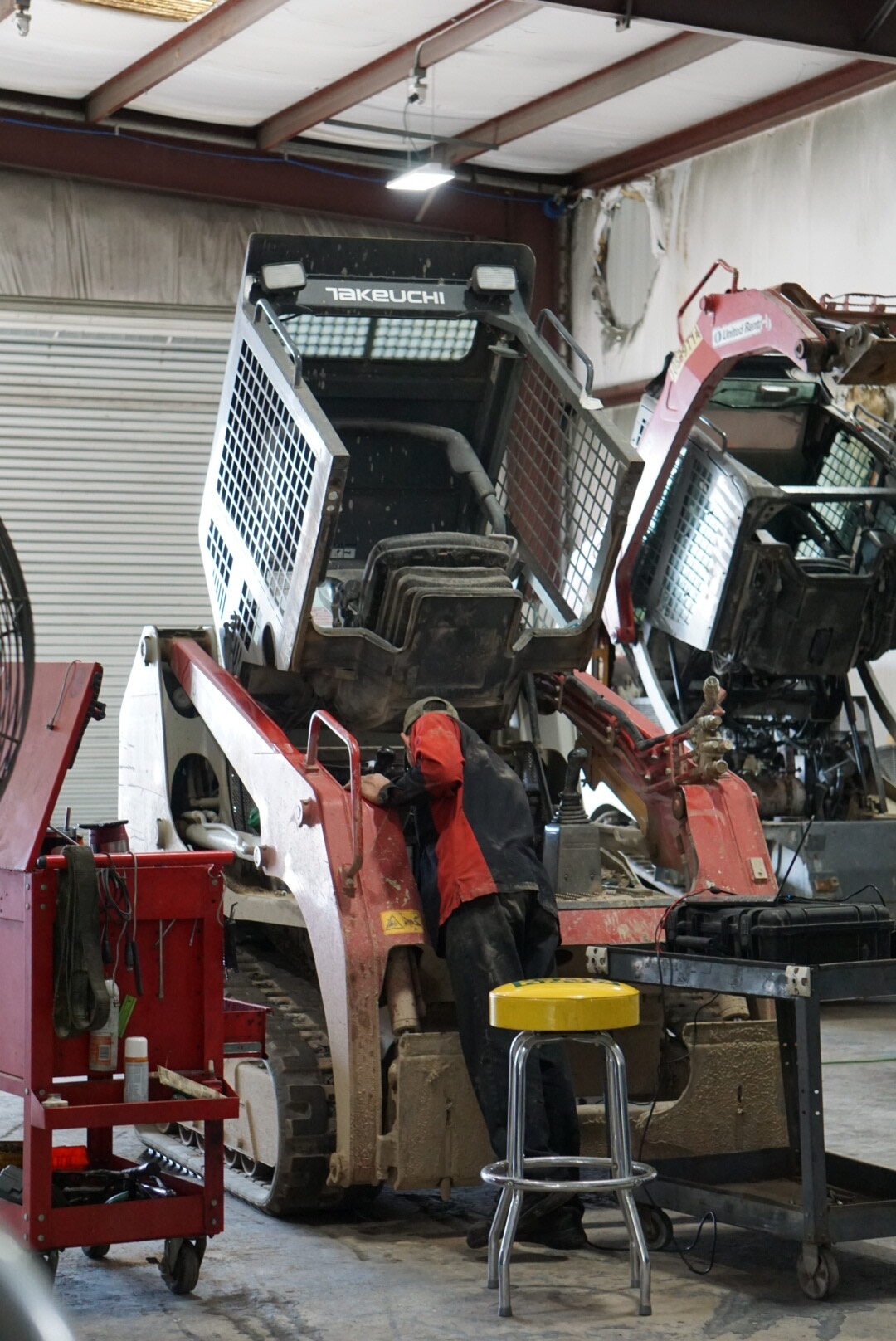 A man working on an old truck in a garage.