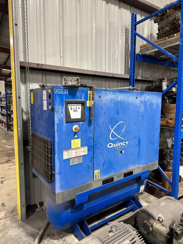 A blue machine is in the middle of a warehouse.
